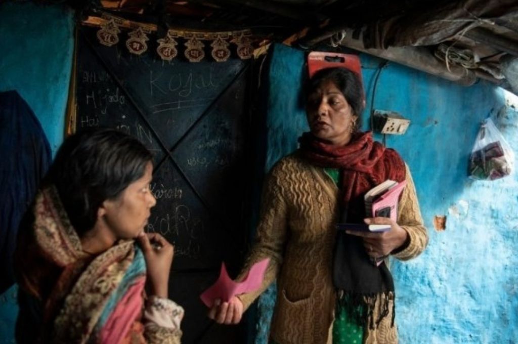 महिला को गुलाबी पर्ची दिखाते हुए हकदर्शक (एक संगठन) की फील्ड वर्कर-फ़ील्ड कार्यकर्ता कौशल विकास