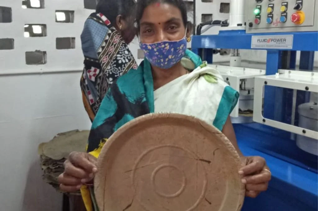 रीना सेठी कारख़ाने में एक पत्तल पकड़े हुई-पर्यावरण हितैषी