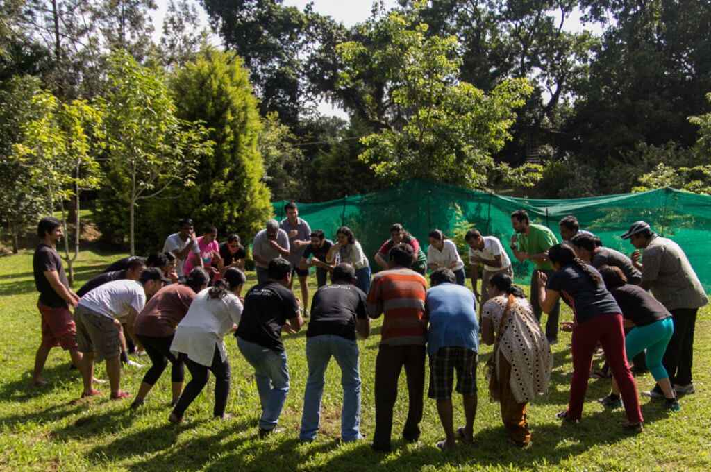 हरियाली से घिरे पुरुष और महिलाएं एक घेरे में-जन-केंद्रित NGO