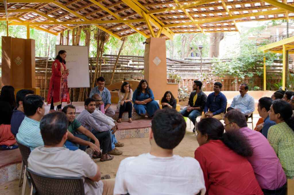 घेरे में बैठे पुरुष और महिलाएं-जन-केंद्रित NGO