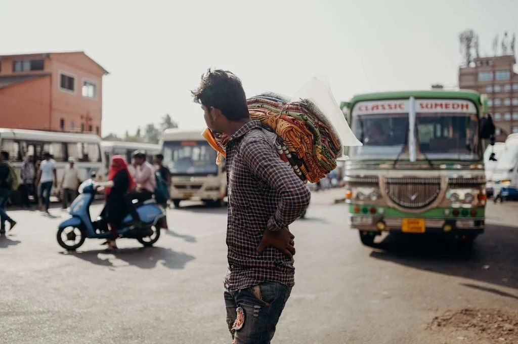 प्लेड शर्ट पहना एक आदमी सड़क पर चल रहा है_मनरेगा