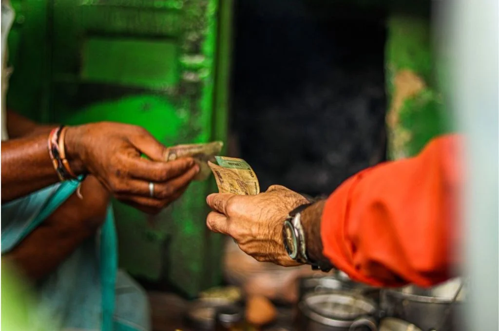एक औरत और एक आदमी के हाथों में पैसे-फंडरेजिंग एनजीओ
