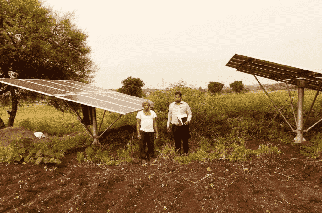 खेत मे सोलर ट्यूबवेल के पास खड़े 2 व्यक्ति_पीएम कुसुम योजना