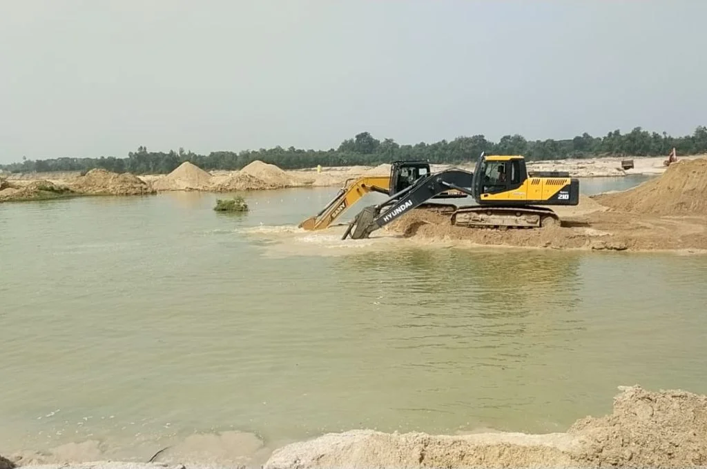 एक ट्रक नदी से रेत निकालते हुए_रेत खनन