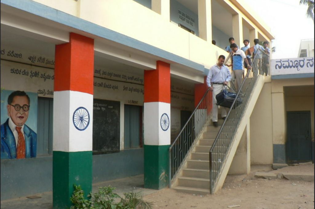 स्कूल भवन के बाहर शिक्षक और बच्चे_संवैधानिक मूल्य