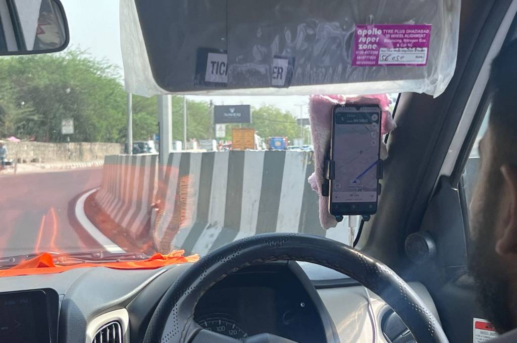 अपने फ़ोन से रास्ता देखता कैब ड्राइवर_गर्मी