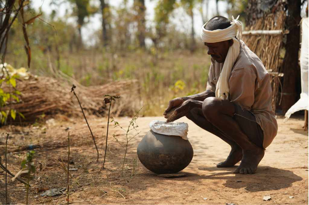 घड़े मे अनाज भरता एक किसान_मिलेट किसान