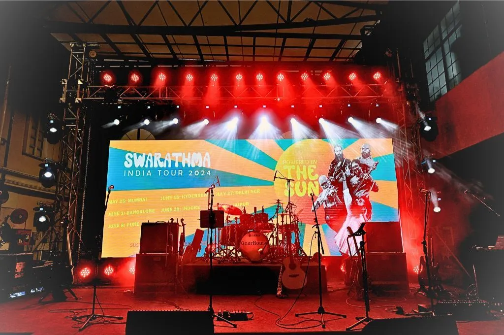 एक लाईटों से जगमगाता स्टेज और उसमें रखे वाद्य यंत्र_नवीकरणीय ऊर्जा