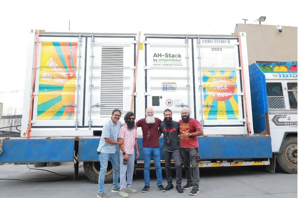 एक ट्रक के साथ फोटो खिंचवाते कुछ लोग_नवीकरणीय ऊर्जा