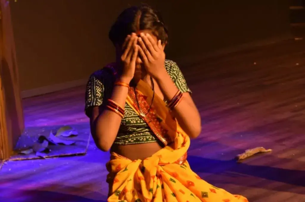 चेहरे को हाथों से ढांके हुए एक महिला—गोंडी भाषा