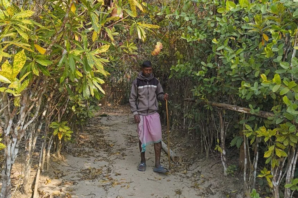 तस्वीर में रबर की फसल के पास सुखराम गौर खड़े हैं_गौर समुदाय