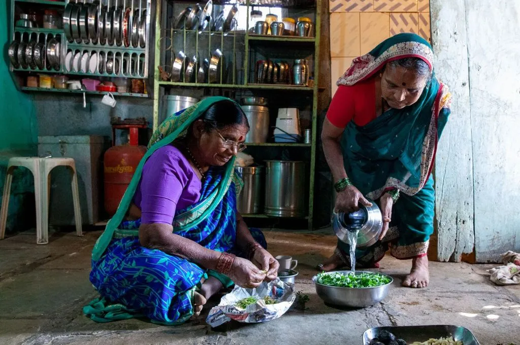 दो बुजुर्ग महिलायें रसोई में खाना बनाते हुए_पारंपरिक ज्ञान