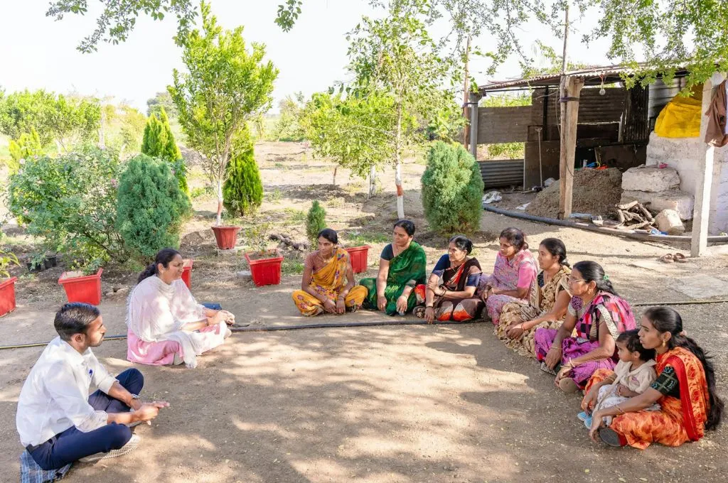 जमीन पर बैठकर चर्चा करते कुछ लोग_ लर्निंग और डेवलपमेंट