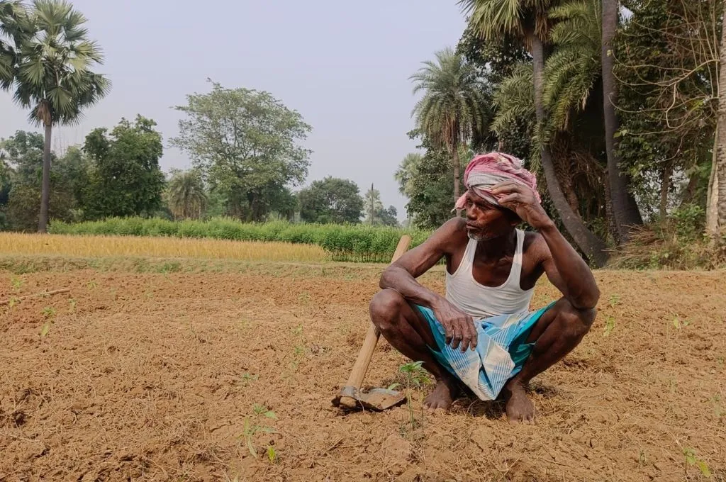 ज़मीन पर फावड़ा लेकर बैठा हुआ एक व्यक्ति_ताड़ी 