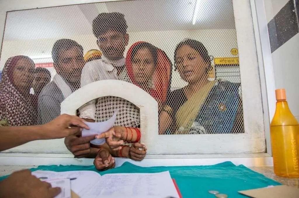 एक काउंटर के दूसरी तरफ मजदूर खड़े हैं_सरकारी योजना