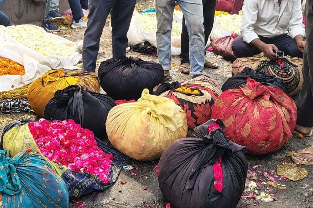 फूलो की गठरियो के साथ लोग_फूलों की खेती